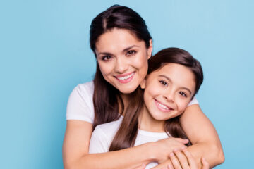 smiling baby girl with mother having good oral health in Whitby, Ontario.